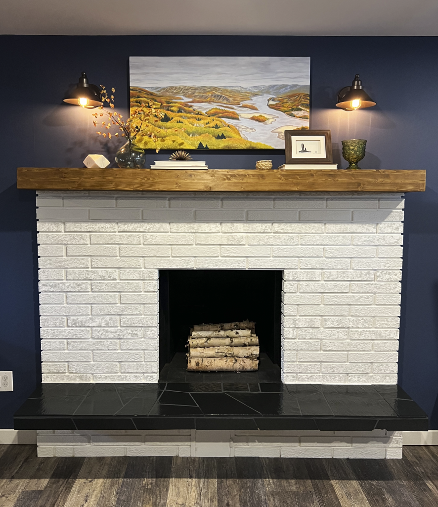 White brick fireplace with a new wood mantle styled