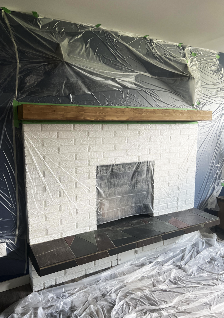 Freshly stained wood ,mantel with wall behind taped and hoarded off for protection