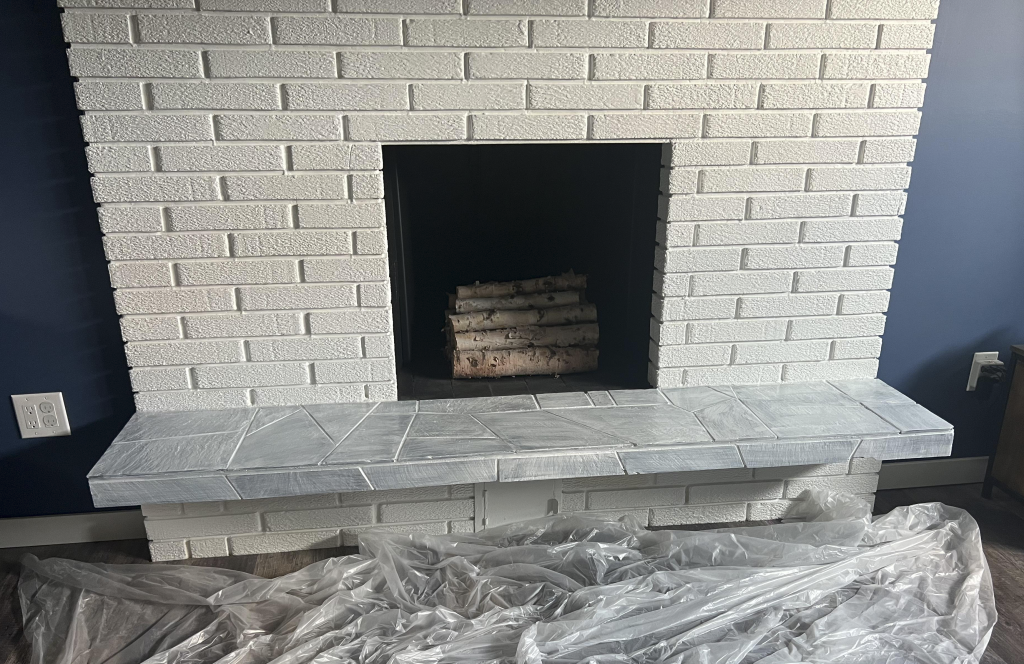 White brick fireplace with primer on the hearth