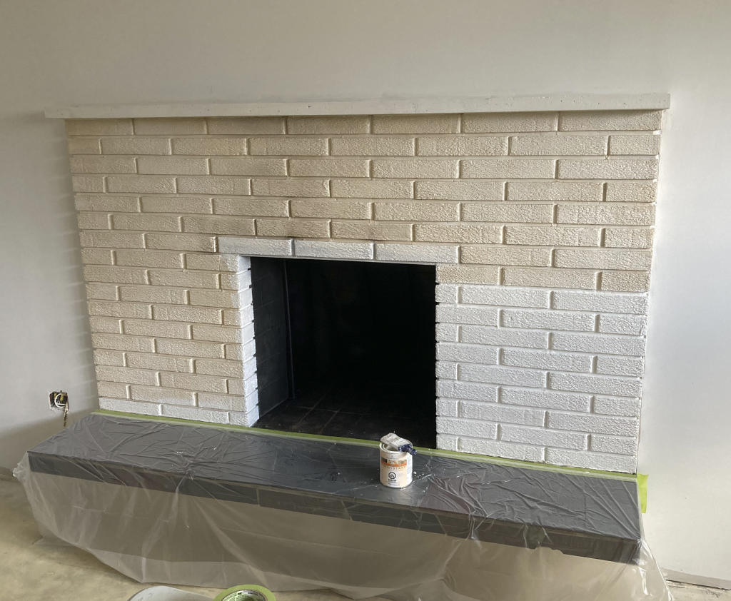 Old brick fireplace getting a fresh coat of white primer