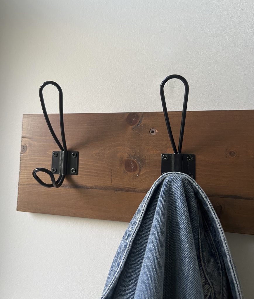 Close up of wooden coat rack showing the stain color and finish